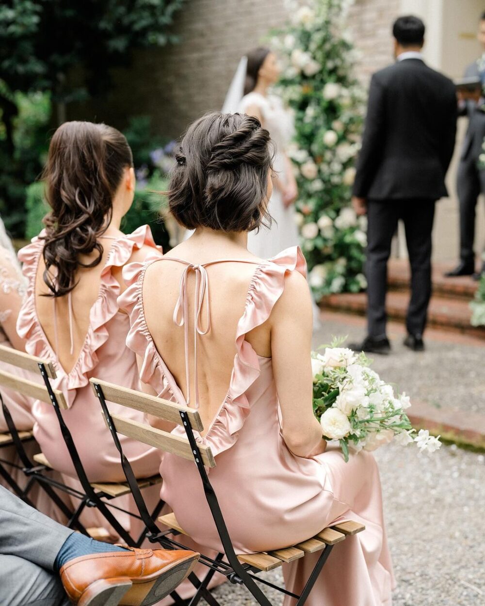 オープンバックのピンクブライズメイドドレスを着た女性たちが結婚式で注目を集めるバックビュー